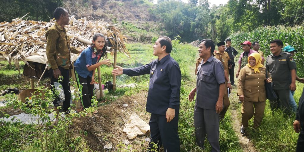 ket foto:Terkelin brahmana SHBeserta rombongan saat menelusuri jalan setapak ditumbuhi semak belukar yang baru dibabat perangkat desa setempat dan bertemu masyarakat di perladangan.foto terkelinbukit.