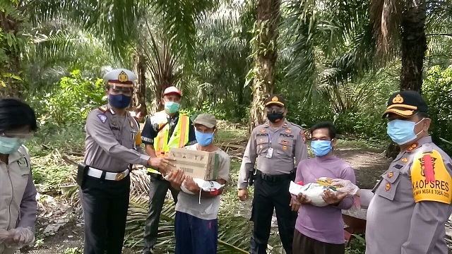 Kapolres Batu Bara AKBP Ikhwan Lubis didampingi Kabag Sumda, Kompol Sri Pinem, Kordinator KSJ, Ahmad Yani SH menyambangi puluhan buruh tani, menyerahkan paket sembako di Desa Air Hitam, Kecamatan Datuk Lima Puluh, Batu Bara Sumatera Utara, Jumat 8/5/2020.