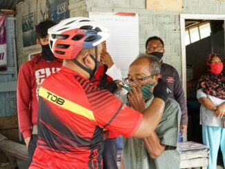 Kapolres Simalungun AKBP Agus Waluyo SIK memakaikan masker ke masyarakat