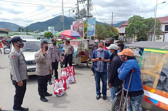 Polsek Balige memberikan sembako bantuan Bapak Presiden RI Ir. Joko Widodo kepada warga Balige di sekitaran Bundaran Balige, Jalan SM Raja , Selasa (28/10/2020)