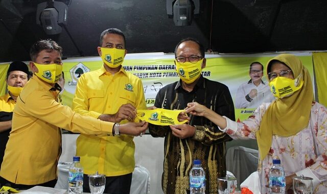 Drs H Musa Rajekshah Mhum dan Mangatas Silalahi menyerahkan masker Golkar kepada Ir Asner Silalahi Mt bersama dr Susanti Dewayani SpA.