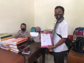 Ket;foto, ketua LPA kab karo Burhan Arif sembiring memperlihatkan bukti pelaporan ke Polres Tanah Karo, foto ,terkelin bukit.