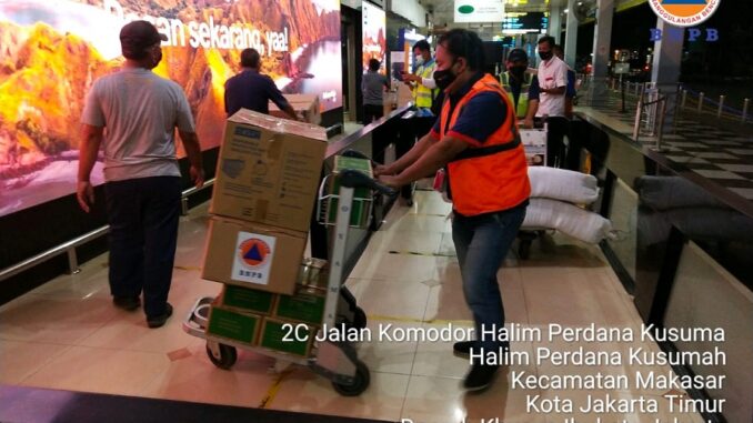 Foto : Petugas logistik dan peralatan BNPB membantu proses pengiriman bantuan bagi warga terdampak bencana banjir bandang di Kabupaten Flores Timur melalui Bandara Internasional Halim Perdana Kusuma, Jakarta, Minggu (4/4) malam. (Kedeputian Bidang Logistik dan Peralatan BNPB)